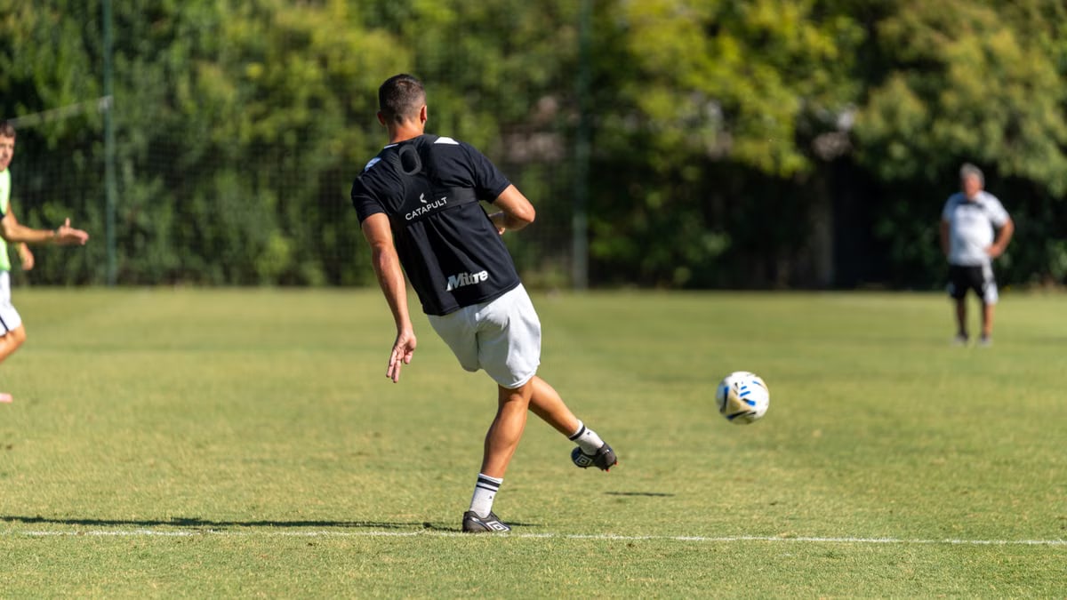 Action shot of a soccer player kicking the ball during an outdoor practice session.